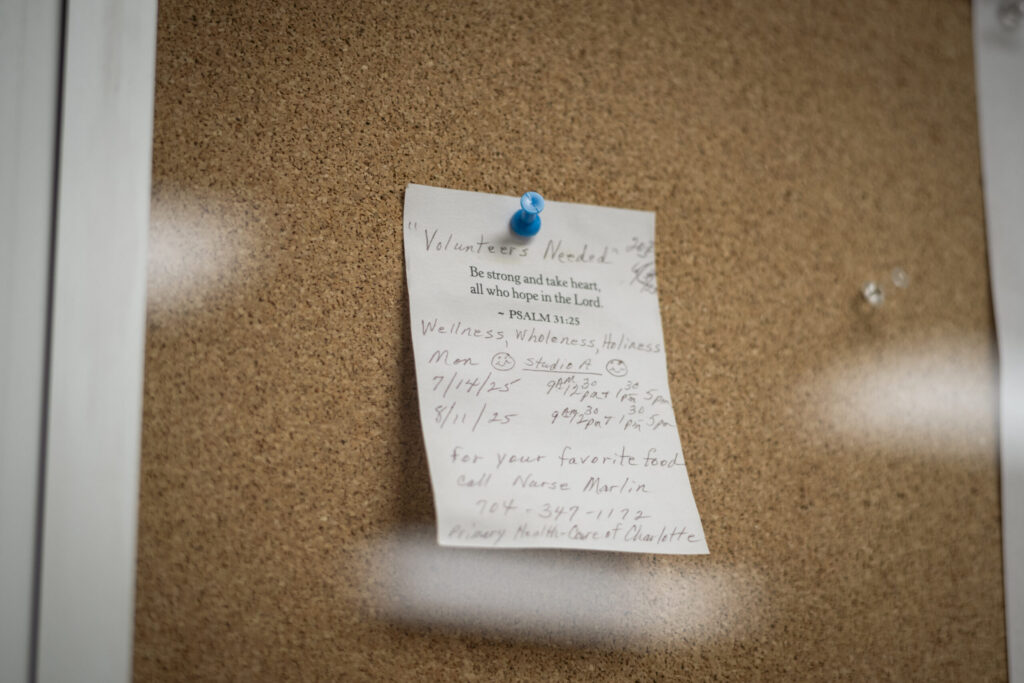 A sign requesting volunteers for Nurse Beth Marlin’s show “Wellness, Wholeness, Holiness” hangs in the lobby of the station. Photo by Logan Cyrus