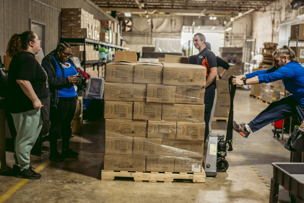 Workers unpack food boxes at Hearts and Hands food pantry on October 30, 2025.