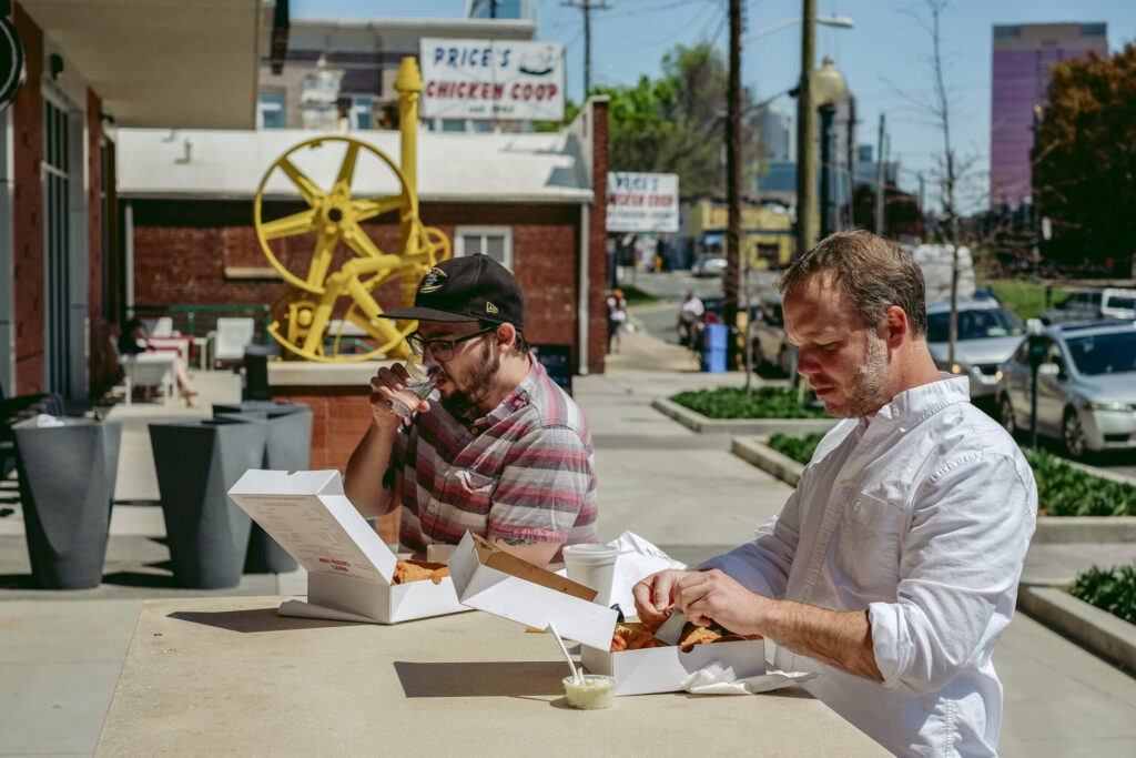 Current Charlotte magazine publisher Andy Smith and former editor Michael Graff eat Price's Chicken Coop