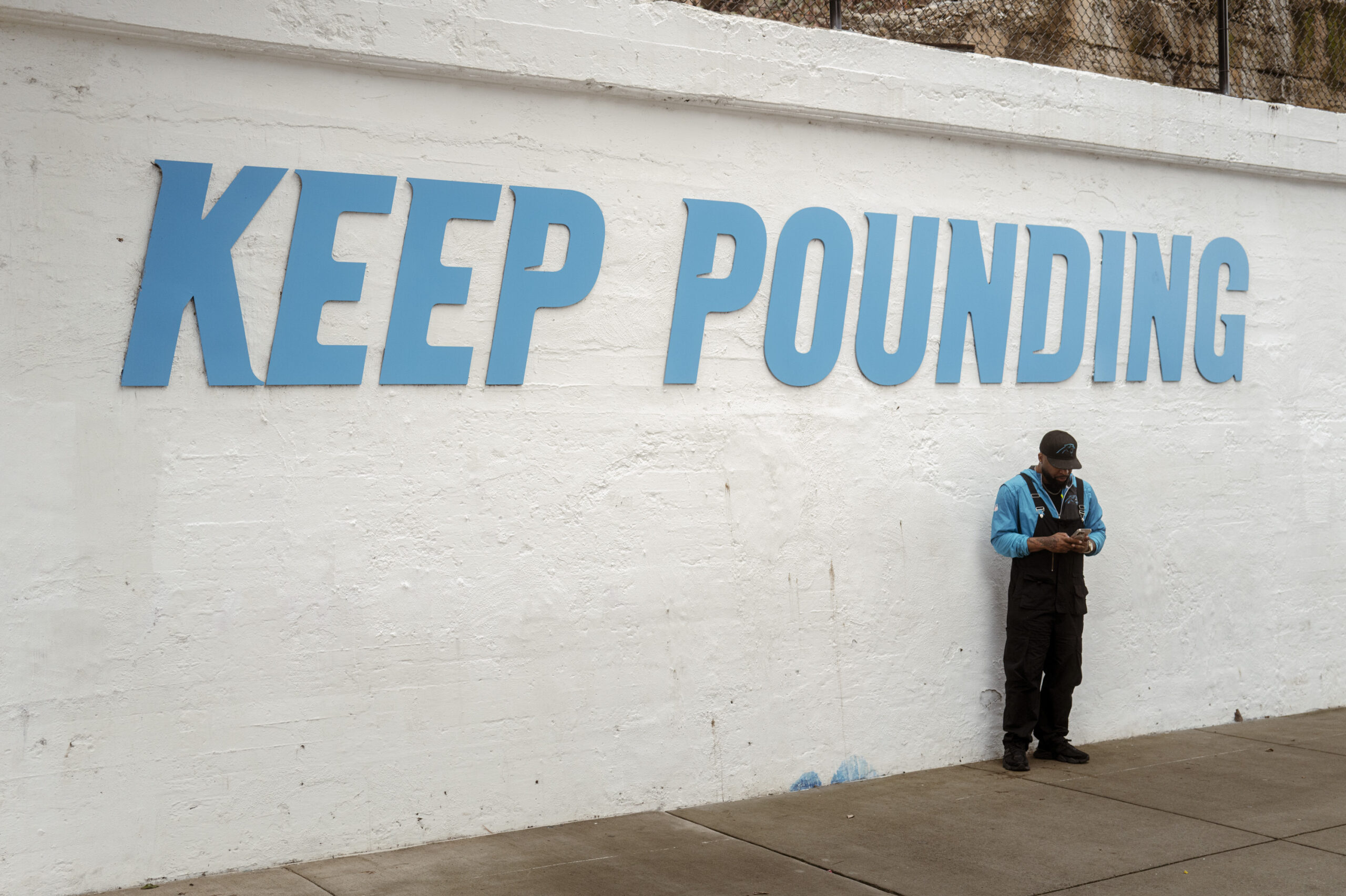 Panthers fan under Keep Pounding sign